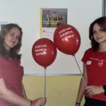 Dwie wolontariuszki z balonami w ręku, na balonach napisy Zostań dawcą szpiku.